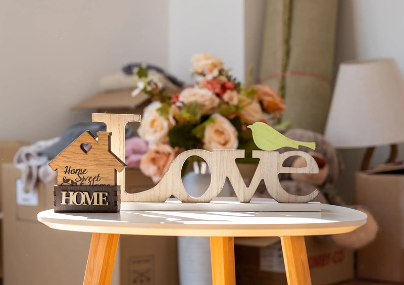 Decorative "Love" sign with bird on table.